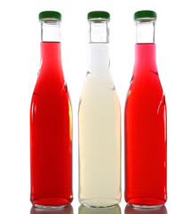 Colorful alcoholic beverages in glass bottles isolated on white