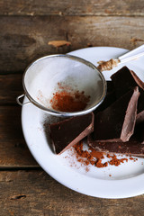 Bittersweet chocolate chunks with strainer of cocoa
