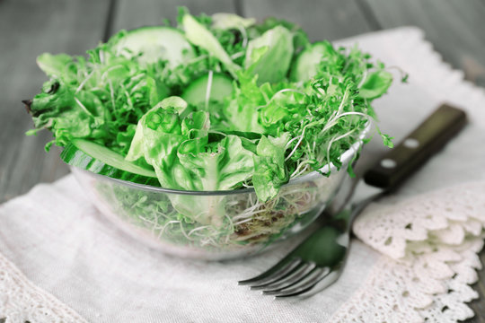 Cress salad with sliced cucumber and greens in glass bowl with