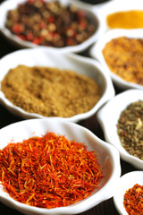 Different kinds of spices in ceramics spoons, close-up,