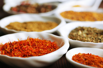 Different kinds of spices in ceramics spoons, close-up,