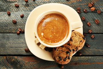 Cup of coffee and tasty cookies on wooden background