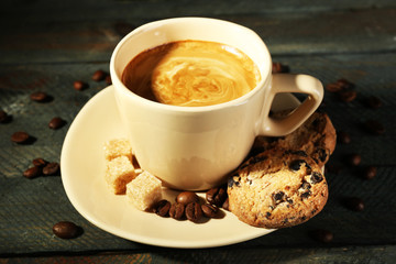 Cup of coffee and tasty cookies on wooden background