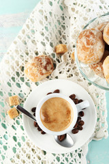 Cup of coffee and tasty cookie on color wooden background