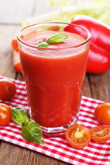 Glass of tomato juice with vegetables on wooden table close up