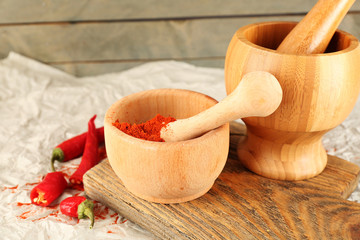 Ground red pepper in mortar with chili pepper