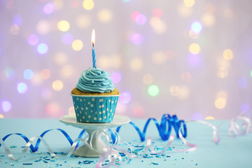 Delicious cupcake on table on light background