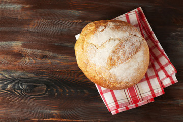 Fresh bread on napkin on wooden background