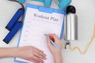 Gordijnen Sports trainer amounts to workout plan close-up © Africa Studio
