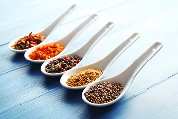 Zelfklevend Fotobehang Different kinds of spices in ceramics spoons, close-up, © Africa Studio