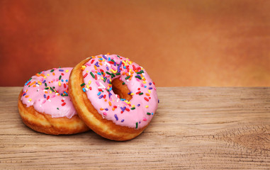 Tow Donuts with Sprinkles on wooden background