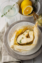 Cod fillets  baked in parchment paper with slices of lemon