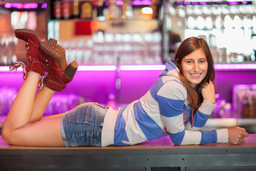 Woman laying on a bar table