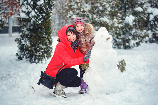 Happy mother and kid playing on snow