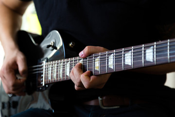 Guitarist play on black electric guitar