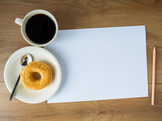 blank paper with coffee cup and pencil and donut on wooden backg