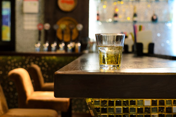 Empty bar with a tumbler of whiskey on the counter