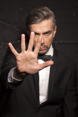 Fototapeta na wymiar handsome man in a suit shows the stop hand
