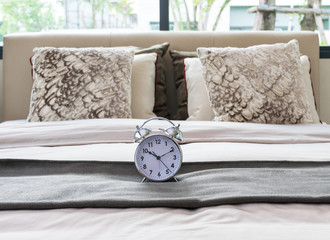 classical alarm clock on bed
