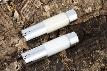 two shiny pure collagen bottles on tree trunk