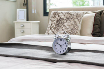 classical alarm clock on bed