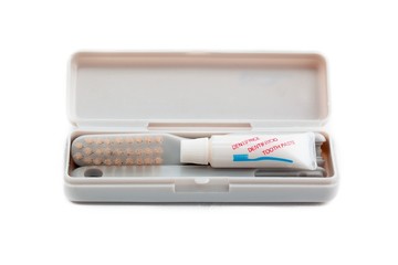 close up shot of toothbrush and toothpaste in case