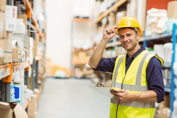 Portrait of warehouse worker with clipboard - Powered by Adobe