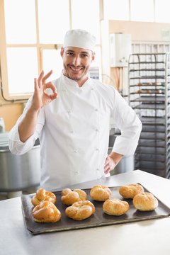 Happy baker showing tray of rolls