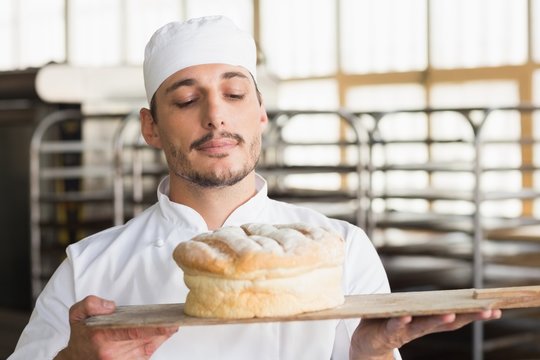 Baker smelling a freshly baked loaf