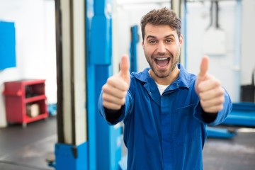 Smiling mechanic showing thumbs up