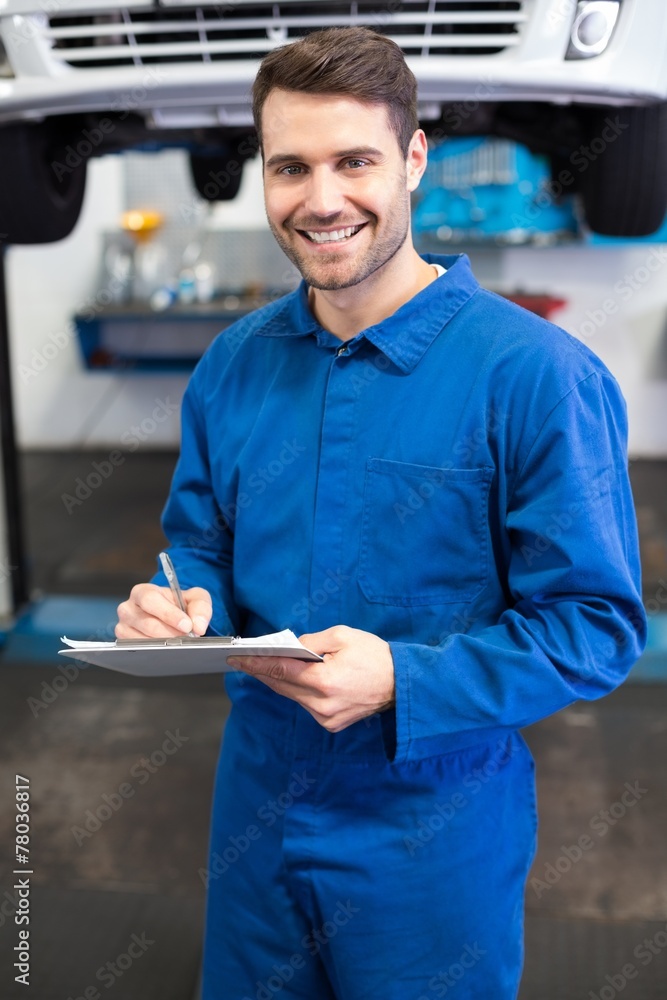 Poster smiling mechanic looking at camera