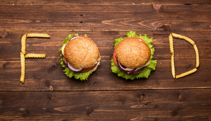 Big burgers forming word food on wooden background