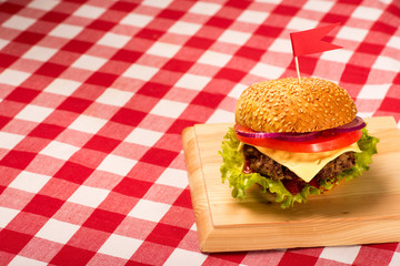 Tasty burger with flag, french fries and beverage