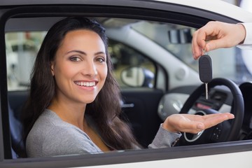 Salesman giving keys to a smiling woman