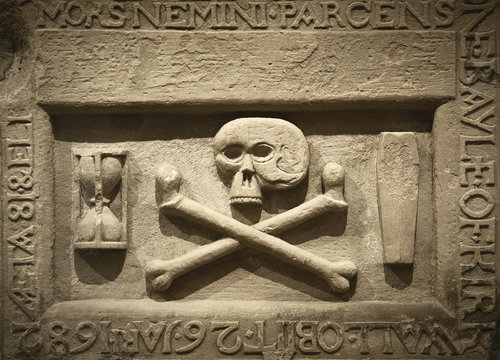 Skull and cross bones with latin text in a tomb