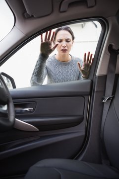 Sad woman looking inside the car