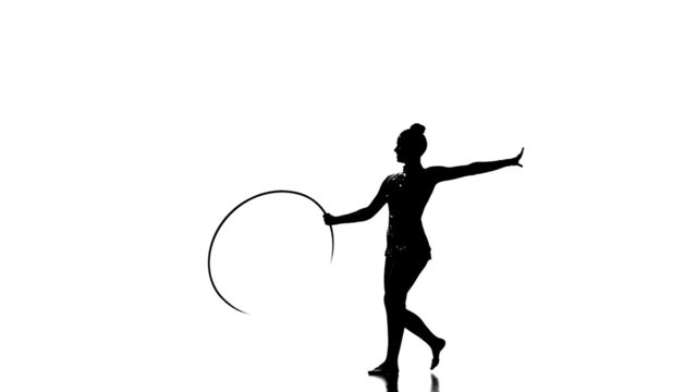Silhouettes Gymnastic stunt with hula hoop from the beautiful
