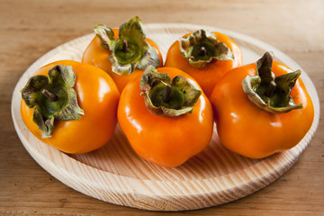 Fresh ripe persimmon on a wooden table