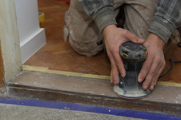 Carpenter at work with electrical sander
