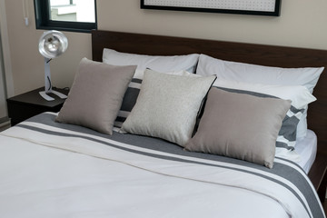 bed and pillows with white lamp on table