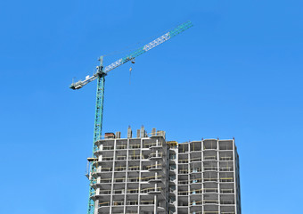 Fototapeta premium Crane and building construction site against blue sky