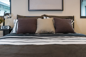 modern bedroom with brown, black and white striped pillows