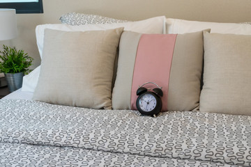 close up of pillows and alarm clock on bed