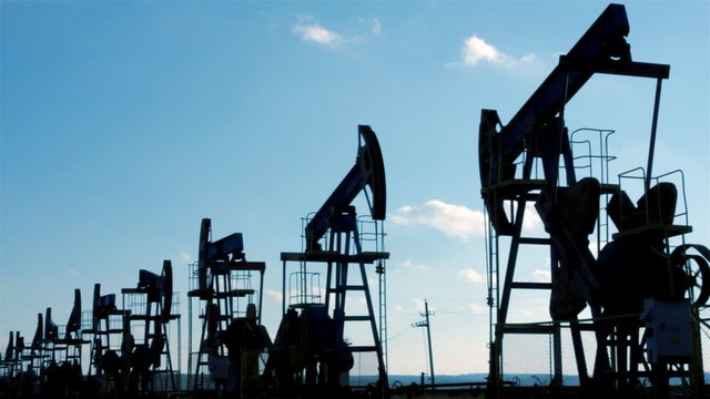 row of many working oil pumps silhouette