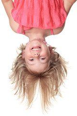 Little beautiful girl in pink clothes upside down isolated on wh