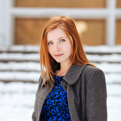 Young beautiful redhead woman posing at winter outdoors