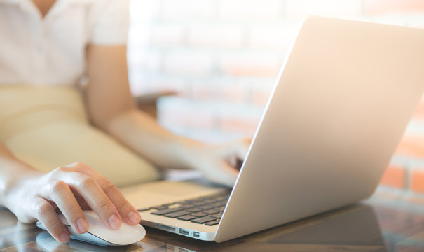 Closeup of business woman hand typing on laptop keyboard with mo