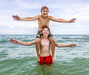 Fototapeta na wymiar boys having fun in the beautiful clear sea