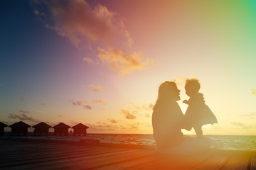mother and little daughter having fun at sunset