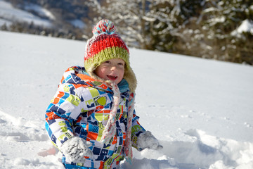 little 3 year old child playing in the snow